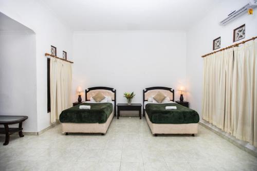 蓝梦岛斯库比都简易别墅假日公园的一间卧室配有两张带绿盖的床和一张桌子