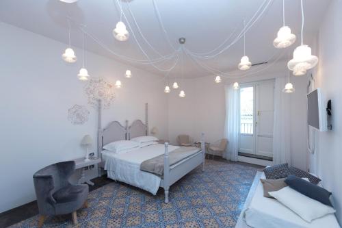 希克利Palazzo Conti Camere & Suites的一间卧室配有一张床、一把椅子和一张沙发