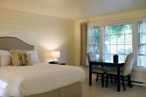 桑威奇萨迪沃旗宾馆的卧室配有一张床和一张桌子及椅子