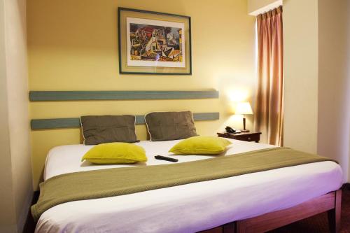 利马卡马纳酒店 的一间卧室配有一张带黄色枕头的大床