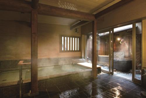 高山田边旅馆的带浴缸和浴缸的浴室。