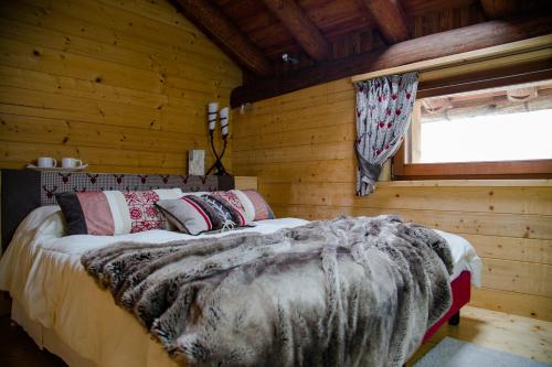 布吕松Au Rascard的小木屋内一间卧室,配有一张床