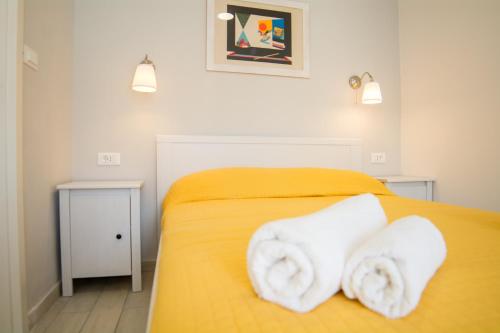 杜布罗夫尼克扎拉公寓的一间卧室配有黄色的床和毛巾