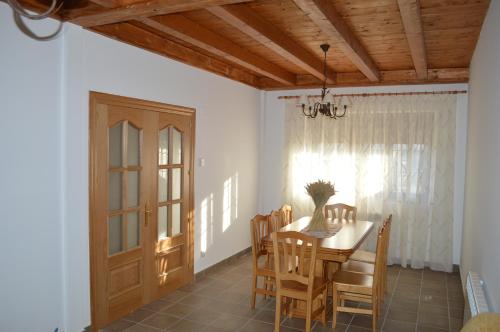 Hinojosa de la SierraLa Laguna的一间带桌椅和门的用餐室