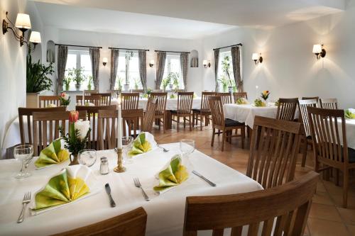 Eching艾钦格霍夫酒店的一间设有白色桌椅的用餐室