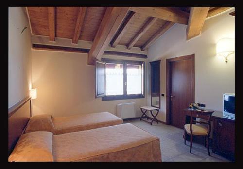 费拉拉兰德卡特那酒店的一间卧室配有两张床和电视。