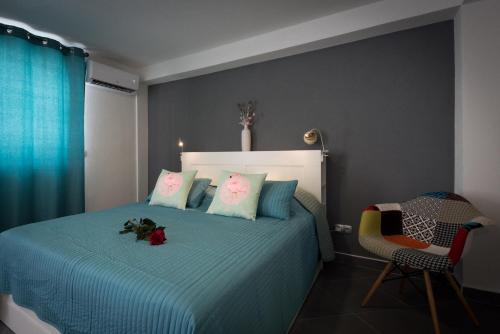 特罗吉尔Studio Tironi的一间卧室配有一张带蓝色床单的床和一把椅子