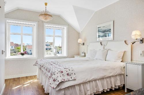 卡琳贡Lotshotellet的一间卧室配有一张带白色床罩的床和2个窗户