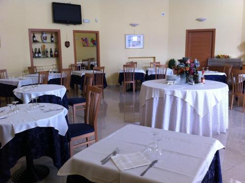福贾Hotel Atleti的用餐室配有桌椅和白色的桌布