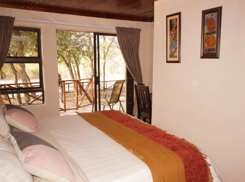 玛洛斯帕克Kruger River Holiday Home的一间卧室设有一张床和一个大窗户