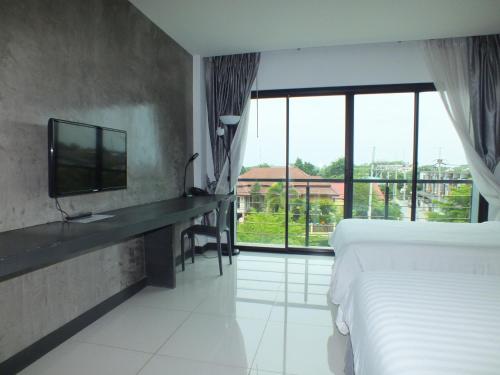 罗勇罗勇胡德里斯酒店的酒店客房设有一张床、一台电视和窗户。