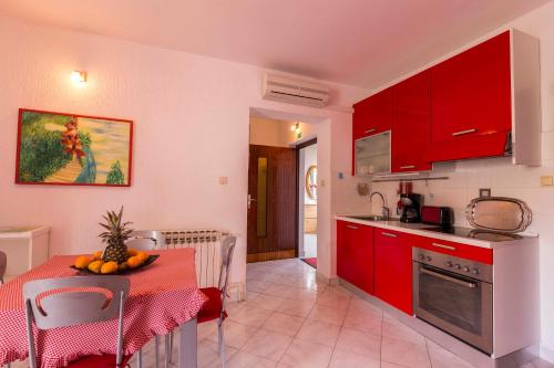 木洛希尼苏西卡公寓酒店的厨房配有红色橱柜和水果桌