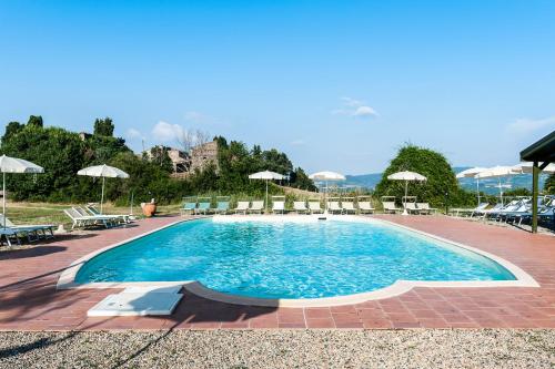 Montecastelli彻尔巴约拉村酒店的一个带椅子和遮阳伞的大型游泳池