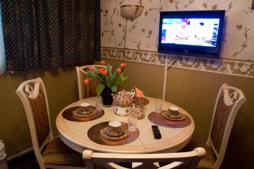 鹿特丹维娜宾馆的餐桌、电视、桌子和椅子