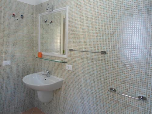 维耶斯泰Appartamento Bilocale a 200 m dalla spiaggia的白色瓷砖浴室设有水槽和镜子