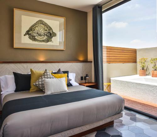 克雷塔罗克里欧酒店的卧室配有1张床铺,享有浴缸的景致