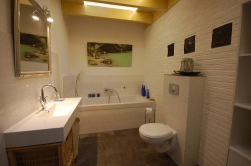 SchuineslootB&B BeZINspiratie的浴室配有盥洗盆、卫生间和浴缸。