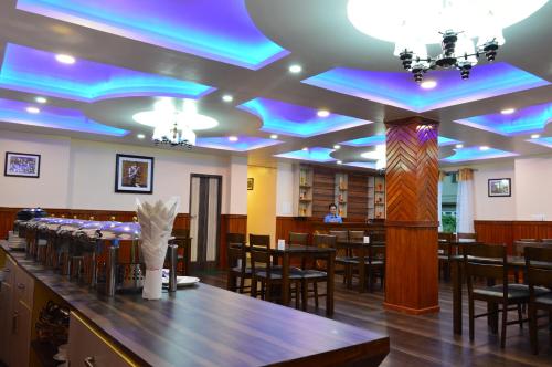 佩林Hotel Golden Sunrise & Spa的一间拥有蓝色灯光的天花板用餐室