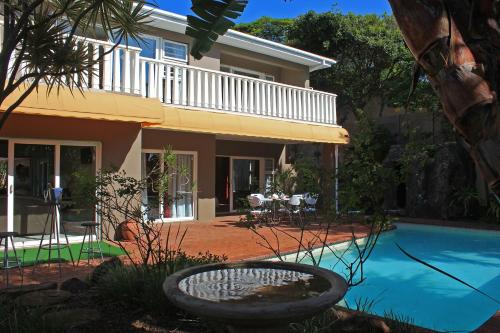 德班Durban Manor Guest House的房屋前有游泳池的房子