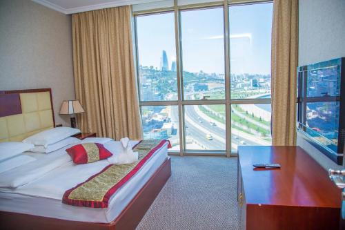 巴库Golden Coast Hotel的酒店客房设有一张床和一个大窗户
