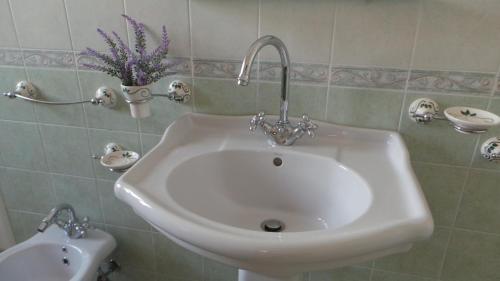 夸尔图-圣埃莱娜Oasi Ottocento的浴室里装有花瓶的白色水槽