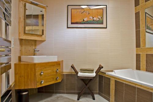 翁弗勒尔穆加多尔公寓的浴室配有水槽、椅子和浴缸。