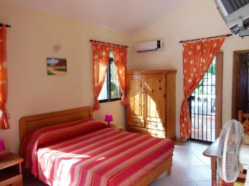 拉斯特拉纳斯百合和可可旅馆的一间卧室配有一张带红白条纹毯子的床