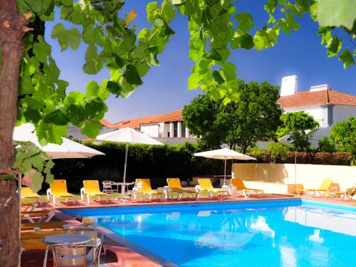 阿尔维图卡斯特洛阿尔维托酒店的一个带椅子和遮阳伞的游泳池