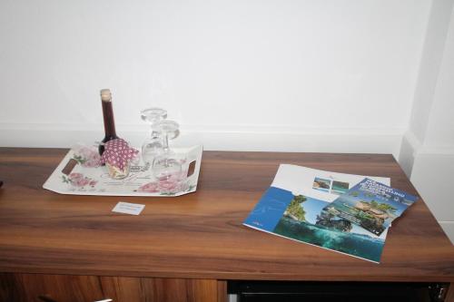 布雷拉Apartmens Villa Antonio 88的一张木桌,上面放着一本书和一瓶葡萄酒