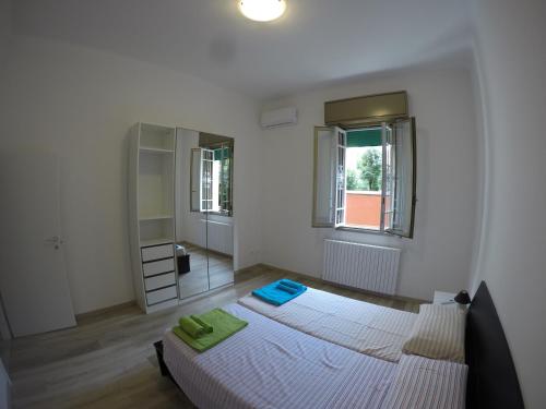 博洛尼亚CornerApartment III的一间白色卧室,配有两张床和镜子