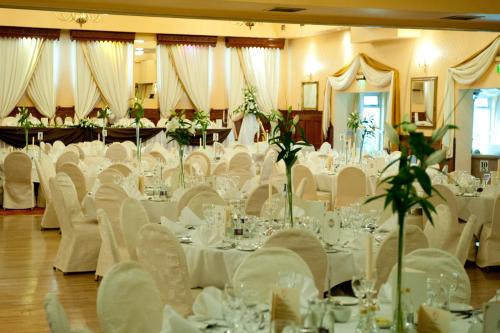 阿斯博伊Darnley Lodge Hotel的宴会厅配有白色的桌子和白色的椅子