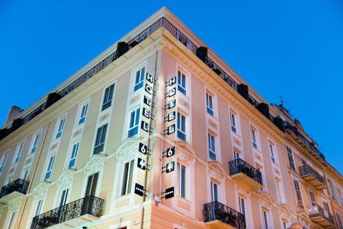 尼斯尼斯64号酒店的粉红色和白色的建筑,背景是蓝色的天空