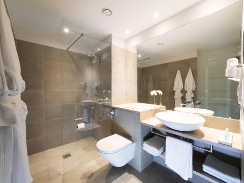 维斯马WONNEMAR Resort-Hotel的一间带水槽、卫生间和镜子的浴室