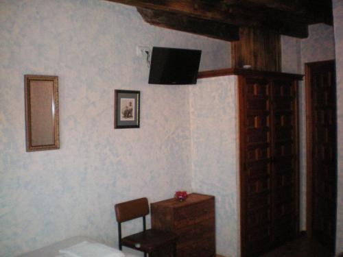 San ViteroHotel Rural Los Perales的一间房间,墙上有椅子和电视
