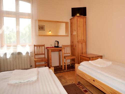 萨诺克朱利亚之家别墅酒店的一间卧室配有两张床和一张桌子及椅子