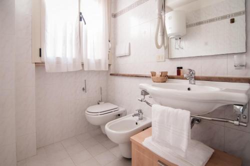 格罗塞托港罗萨海神公寓式酒店的白色的浴室设有水槽和卫生间。