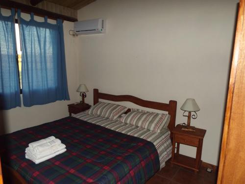 阿尔米隆温泉El Remanso De Almiron的一间卧室配有一张带两盏灯和两条毛巾的床。