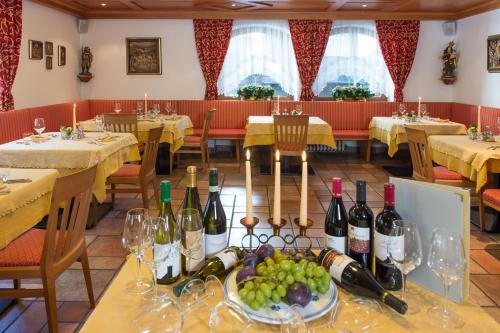 塞尔瓦迪加尔代纳山谷La Truga的一间用餐室,配有酒瓶和葡萄。