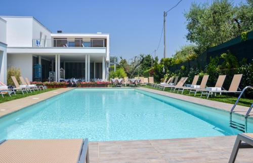 巴多利诺马克西米利安酒店的一个带椅子的游泳池以及一座房子