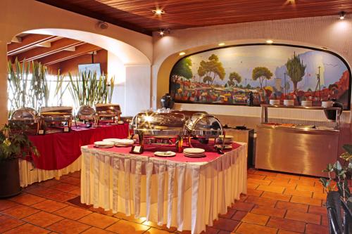 瓦哈卡市福廷广场酒店的一间餐厅,配有餐桌和食物