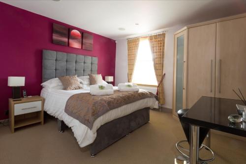 牛津Cherwell Gates 4 Bed Luxury Oxford Apartment for 8 with Roof terrace的一间卧室配有一张大床和紫色墙壁