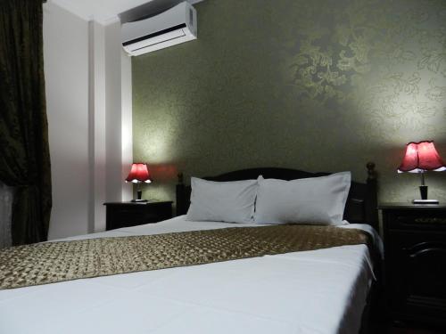 布加勒斯特Hotel Marinii的卧室配有白色的床和两盏灯。