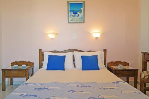 阿吉奥斯普罗科皮奥斯Mina's Studios in Naxos Island的一间卧室配有一张带蓝色枕头的床和两张桌子
