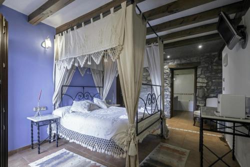 MallaviaHotel Rural Mañe的一间卧室配有一张带天蓬的床