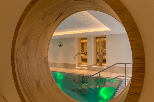 盖洛斯Alpenland Gerlos - Hotel & Breakfast的圆形走廊,带游泳池,位于带镜子的房屋内