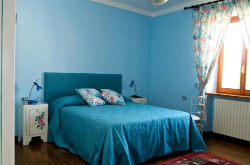 阿特里Arco di San Francesco的蓝色卧室配有蓝色的床和2个枕头