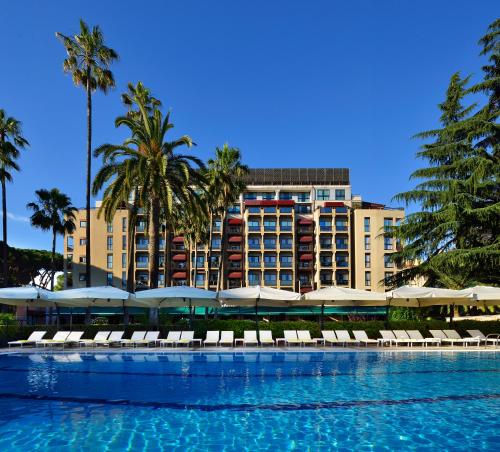 罗马帕克德普林西皮酒店的一个带椅子的游泳池和一个位于酒店后面的酒店