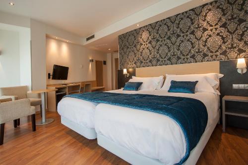 圣塞瓦斯蒂安斯考特而科迪纳酒店的酒店客房配有一张带蓝色毯子的大床
