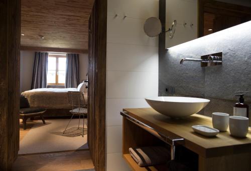 施图本阿尔贝格House Hannes Schneider Stuben的一间带水槽的浴室和一间带床的房间