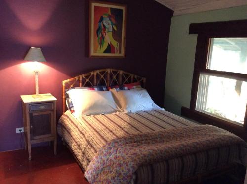 伊利亚贝拉Casa das Ilhas的一间卧室,配有一张床和一个窗户旁边的灯
